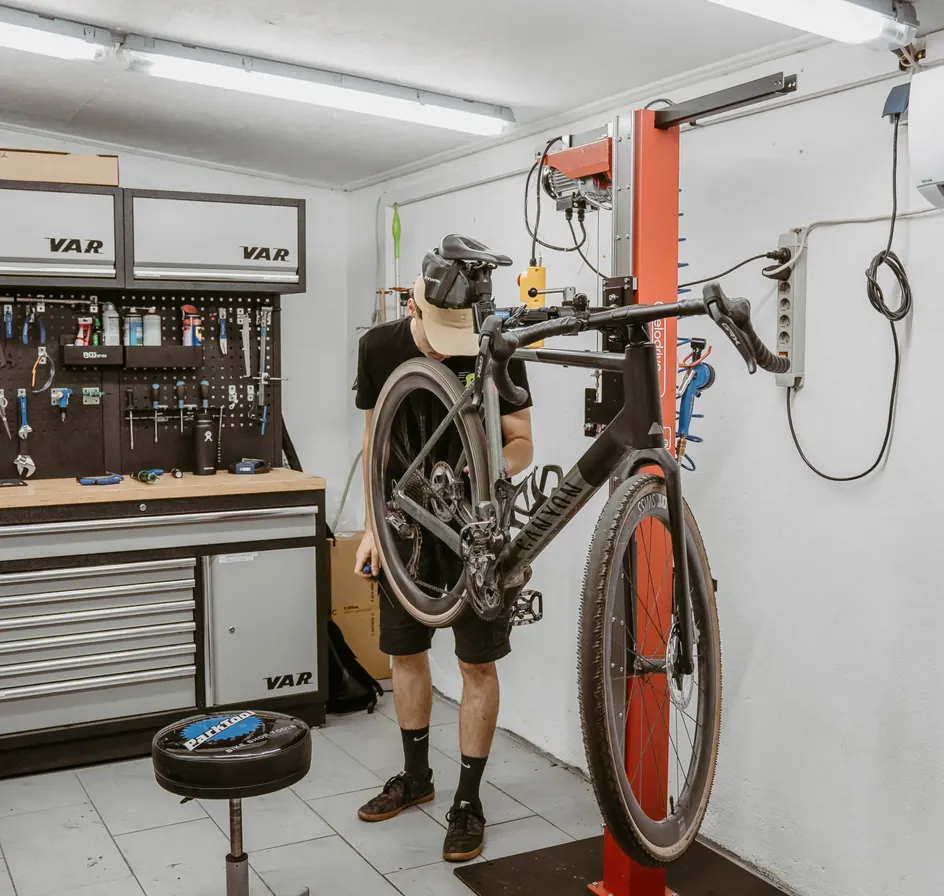 Mechaniker mit einem Rad auf dem Montageständer